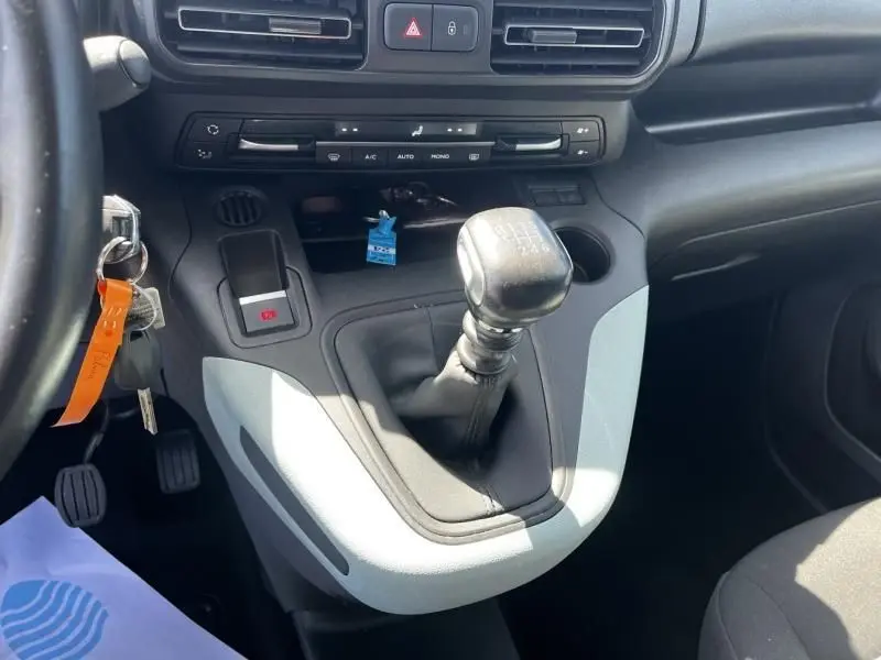 Vue rapprochée de la console centrale du Citroën Berlingo gris métal 2021, avec levier de vitesse manuel et commandes climatisation.