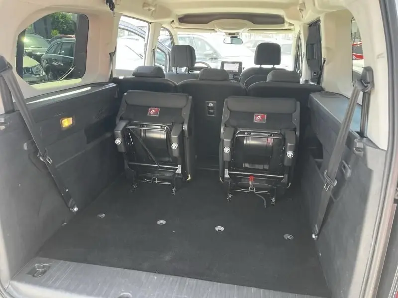 Vue intérieure arrière du Citroën Berlingo XL gris métal 2021, montrant les sièges arrière rabattus et l'espace de chargement.