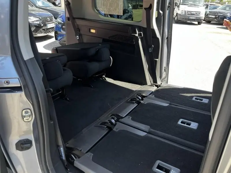 Vue intérieure côté droit du Citroën Berlingo XL gris métal 2021, sièges arrière rabattus et espace de chargement visible.