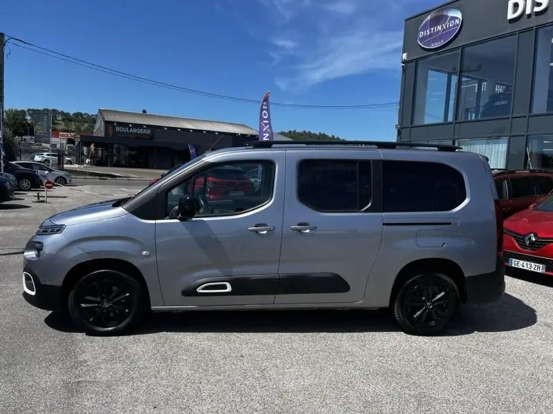 Vue de profil côté gauche du Citroën Berlingo XL gris métal 2021 avec jantes noires et vitres teintées.