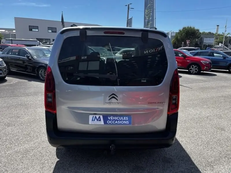 Vue arrière du Citroën Berlingo XL gris métal 2021 avec hayon vitré et feux verticaux rouges, stationné en extérieur.