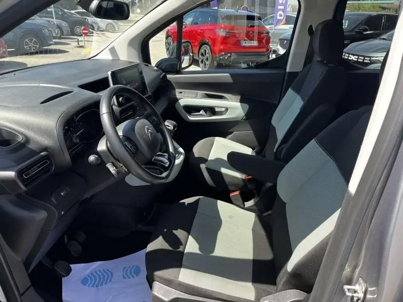 Vue intérieure côté conducteur du Citroën Berlingo XL gris métal 2021, montrant les sièges et le tableau de bord.