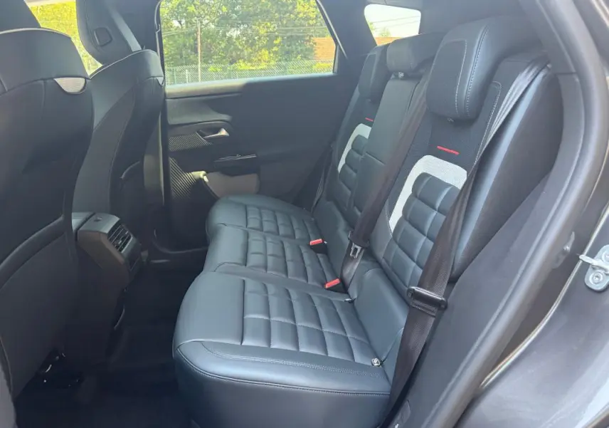 Vue latérale droite de la banquette arrière en cuir noir du Citroën C5 Aircross gris 2026 avec ceintures et appuie-têtes.