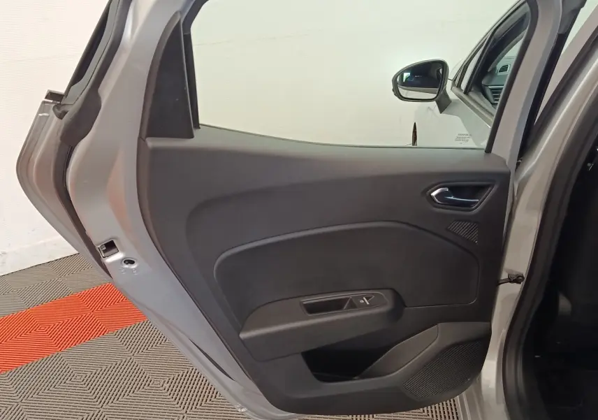 Vue intérieure de la porte arrière gauche gris clair d'une Renault Clio Business TCe 100, avec poignée et commande de fenêtre.