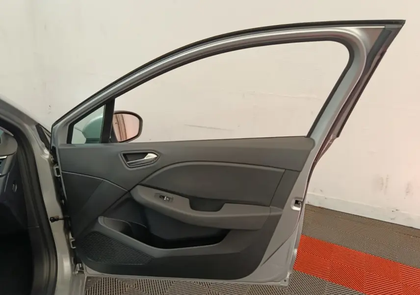 Vue intérieure de la porte avant gauche gris clair de la Renault Clio Business TCe 100, avec poignée et commande de vitre.