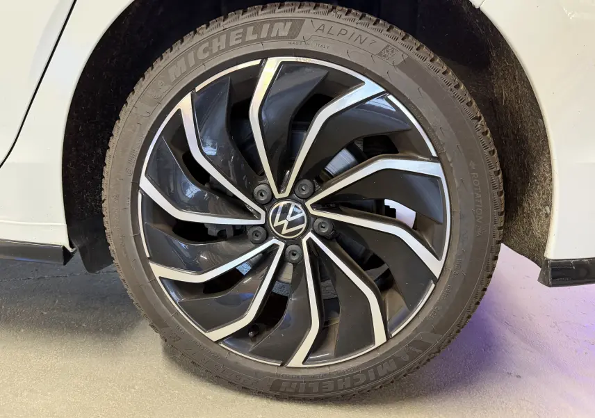 Gros plan sur la jante noire et argentée d'une Volkswagen Golf 2.0 TDI 150 DSG7 R-Line blanche, côté arrière droit.