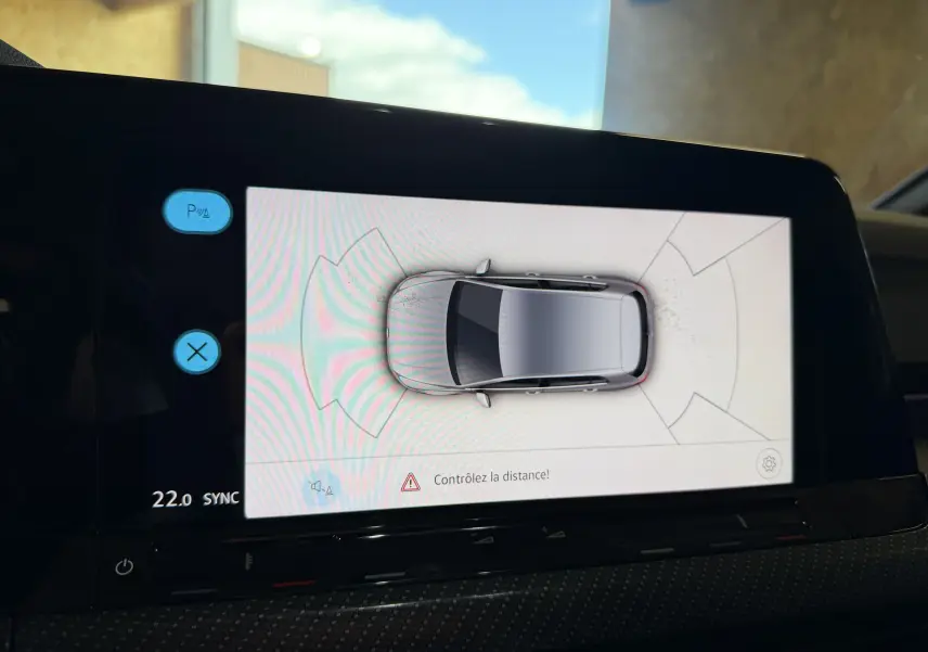 Affichage intérieur de la caméra 360° montrant une Volkswagen Golf blanche vue du dessus avec alertes de distance.