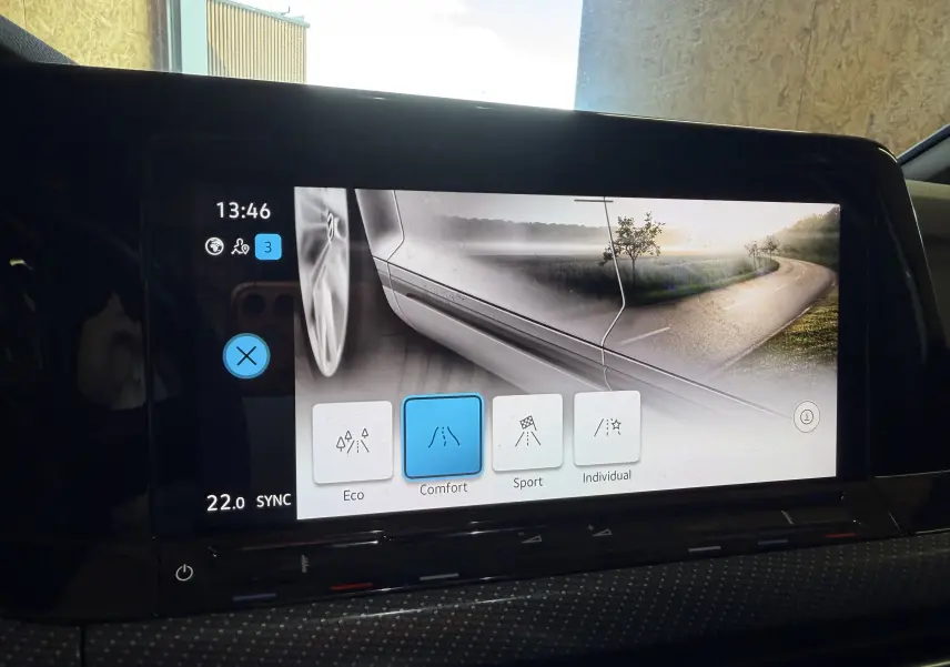 Écran tactile intérieur de Volkswagen Golf 2023 affichant les modes de conduite avec une vue latérale stylisée du véhicule blanc.