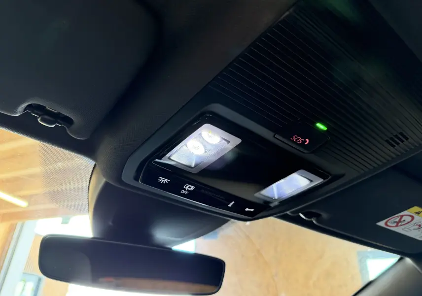 Vue intérieure du plafonnier avec éclairage LED et bouton SOS allumé dans une Volkswagen Golf blanche 2023.