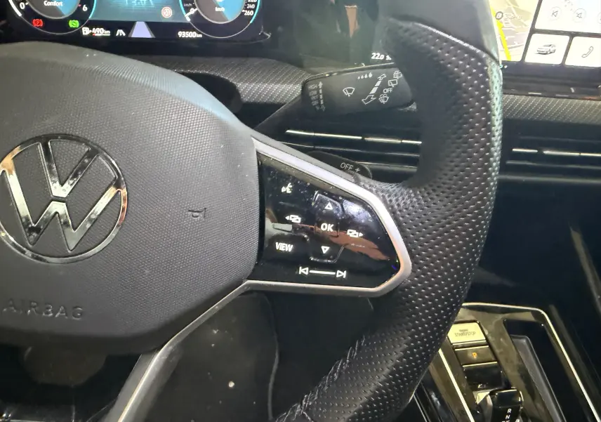Gros plan sur le volant perforé noir de la Volkswagen Golf 2.0 TDI 150 DSG7 R-Line 2023 avec commandes intégrées.