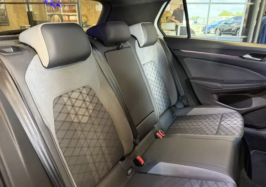 Vue intérieure des sièges arrière de la Volkswagen Golf 2.0 TDI 150 DSG7 R-Line 2023, tissu gris à motifs et cuir noir.