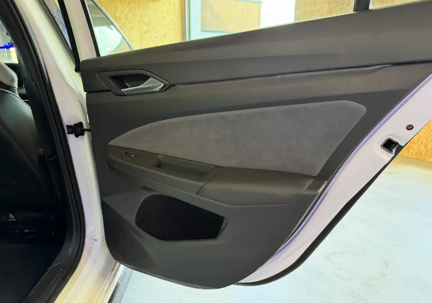 Vue intérieure de la porte arrière droite d'une Volkswagen Golf 2.0 TDI blanche, avec garniture noire et grise.