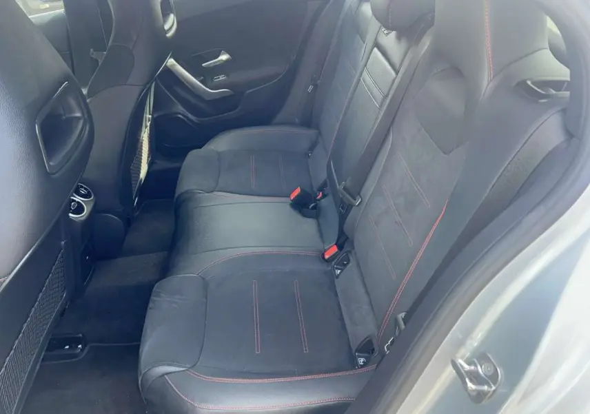 Vue intérieure côté droit de la banquette arrière en cuir tissu noir avec surpiqûres rouges d'une Mercedes Classe A AMG Line argent high-tech metal.