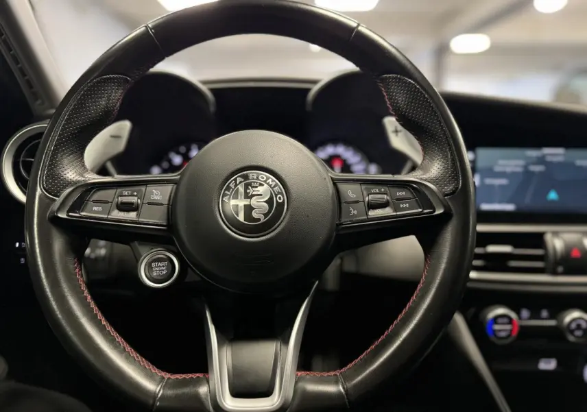 Vue frontale du volant cuir noir de l'Alfa Romeo Giulia 2.2 D 190 BVA Super avec palettes aluminium brossé.