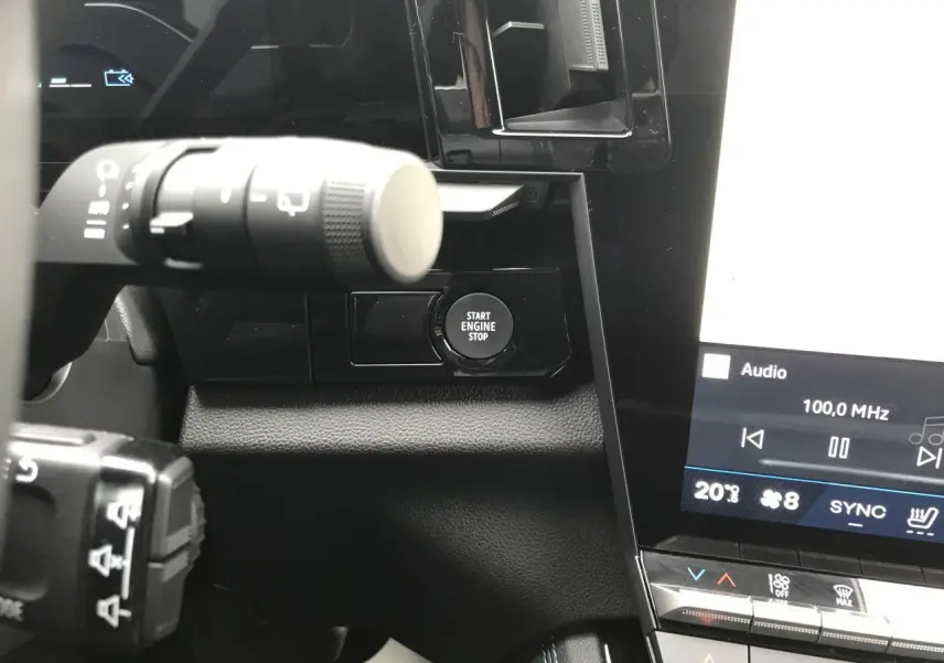 Détail intérieur du tableau de bord côté gauche du Renault Austral gris, avec bouton Start Engine Stop et écran tactile.