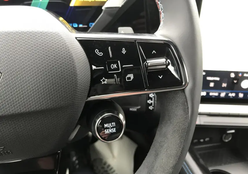 Gros plan sur le volant noir avec commandes tactiles et bouton Multi-Sense dans l’habitacle du Renault Austral 2025.