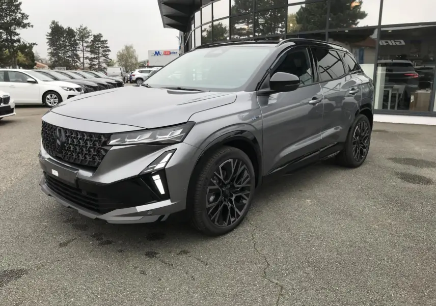 Renault Austral full hybrid gris métallisé et noir, vue 3/4 avant avec jantes noires et toit noir.