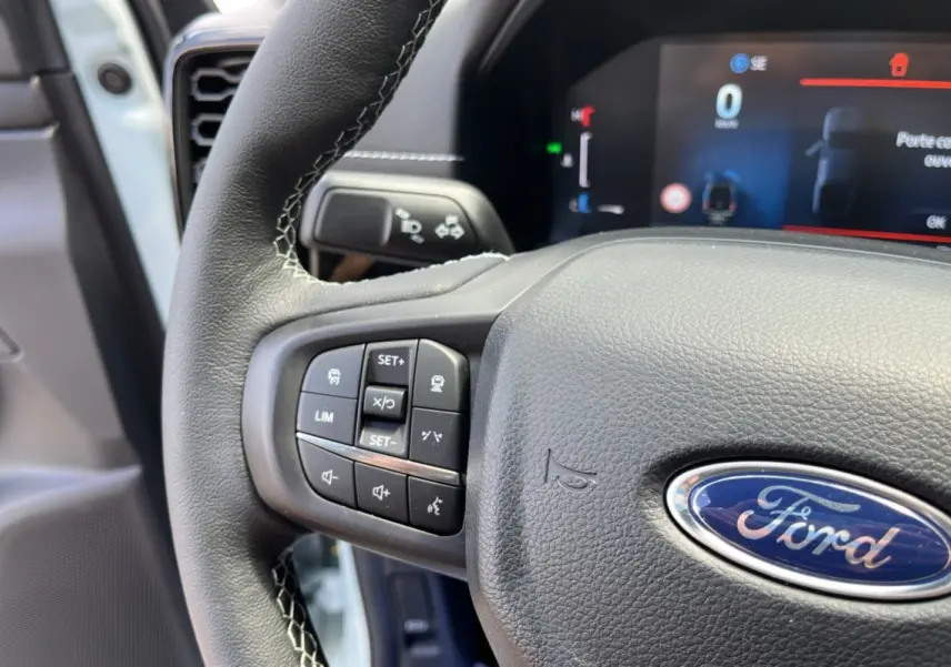 Vue rapprochée du volant cuir multifonctions du Ford Ranger gris zen avec commandes intégrées et tableau de bord numérique.
