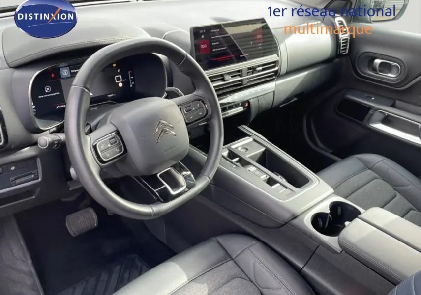 Vue intérieure côté conducteur du Citroën C5 Aircross 2024, tableau de bord et volant en cuir noir avec écran tactile central.