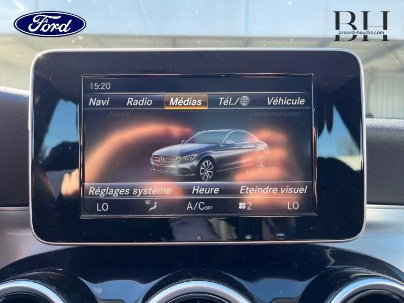 Écran central affichant une image 3D argent iridium de la Mercedes Classe C 200 d Business en profil côté gauche.