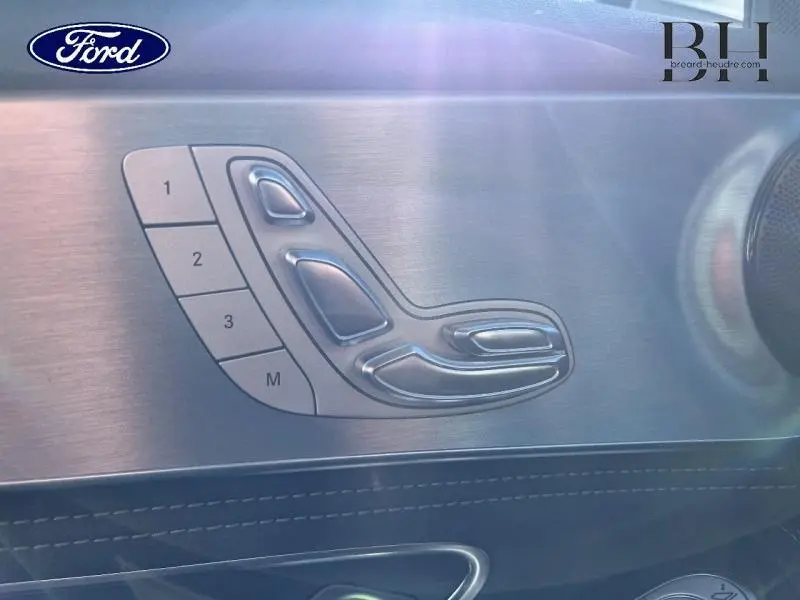 Détail des commandes de réglage électrique des sièges sur la porte côté gauche d'une Mercedes Classe C 200 d Business argent iridium.