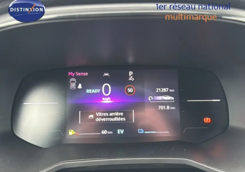 Tableau de bord numérique de Renault Clio hybride 2025 affichant vitesse, autonomie et alertes, vue frontale rapprochée.