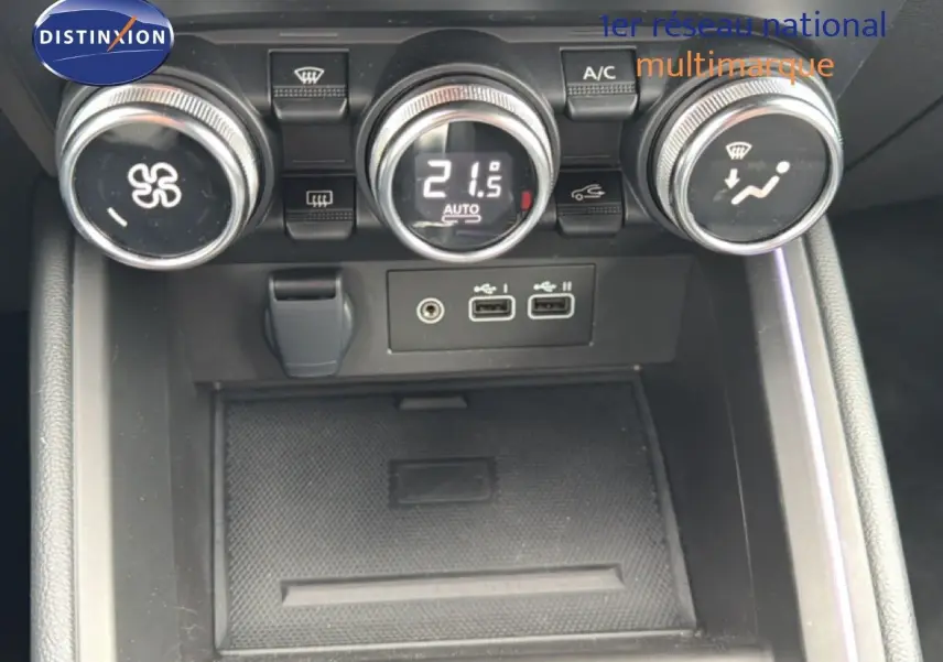 Vue rapprochée du tableau de bord central de la Renault Clio 2025, montrant les commandes de climatisation et ports USB.