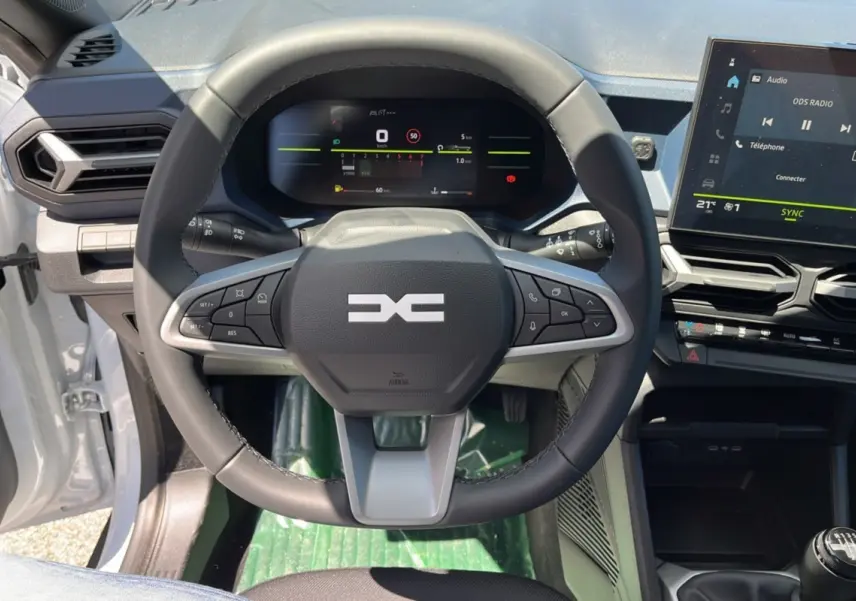 Vue intérieure centrée sur le volant cuir et le tableau de bord digital du Dacia Bigster blanc glacier 2025.