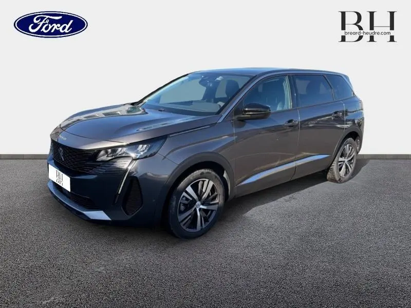 Peugeot 5008 gris Platinium vue 3/4 avant droit, mettant en valeur sa calandre noire et ses jantes alliage.