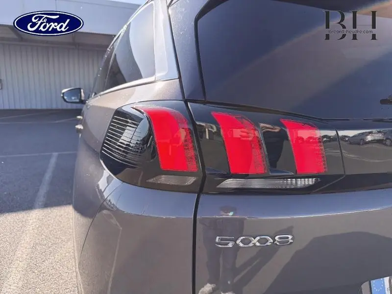 Gros plan sur l'arrière droit gris Platinium du Peugeot 5008 2022, mettant en valeur les feux arrière LED et le logo 5008.