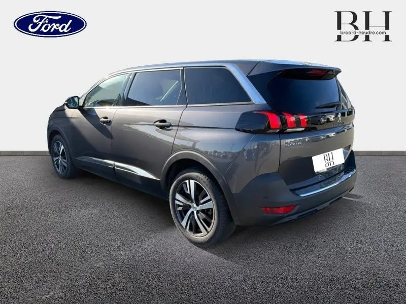Peugeot 5008 gris Platinium vue 3/4 arrière droit, avec feux arrière LED et jantes alliage distinctives.