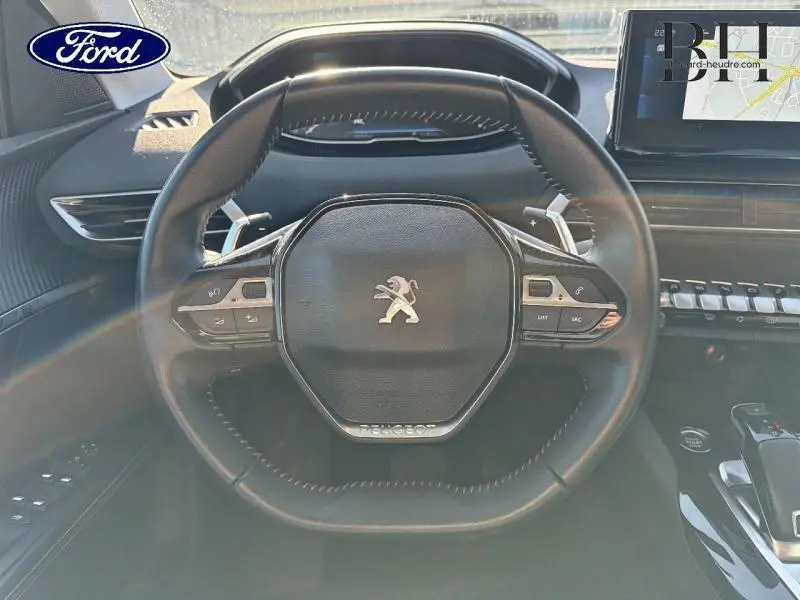 Vue centrée sur le volant cuir noir du Peugeot 5008 2022 avec commandes multifonctions et tableau de bord digital.