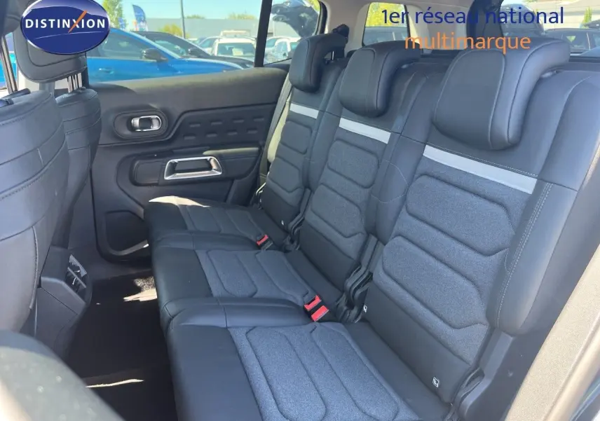 Vue intérieure côté droit montrant la banquette arrière en tissu et cuir noir du Citroën C5 Aircross 2025 hybride.