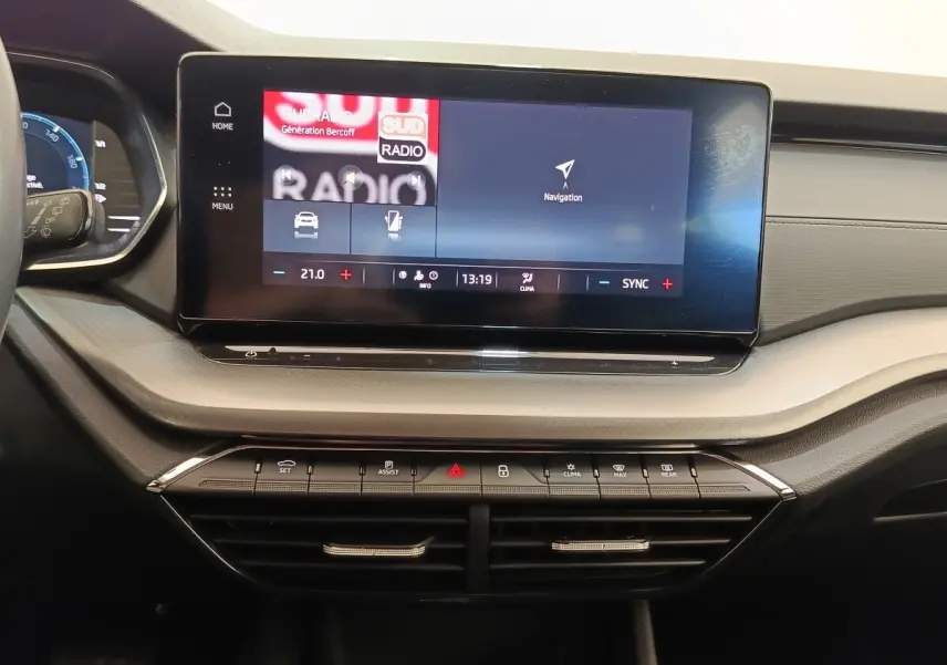 Tableau de bord central de la Skoda Octavia 2023 avec écran tactile large et commandes climatisation visibles.