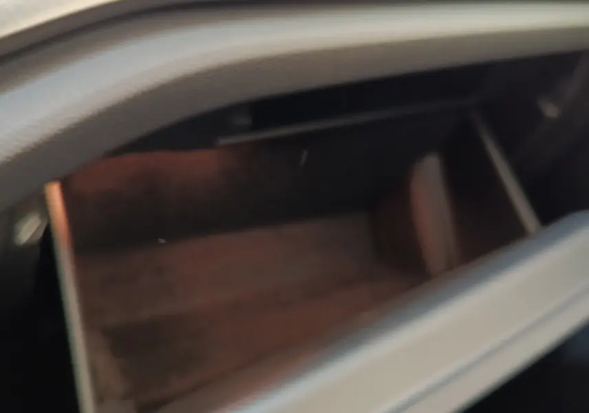 Gant de rangement ouvert dans l'habitacle d'une Skoda Octavia blanche, vue intérieure floue sans autres détails visibles.