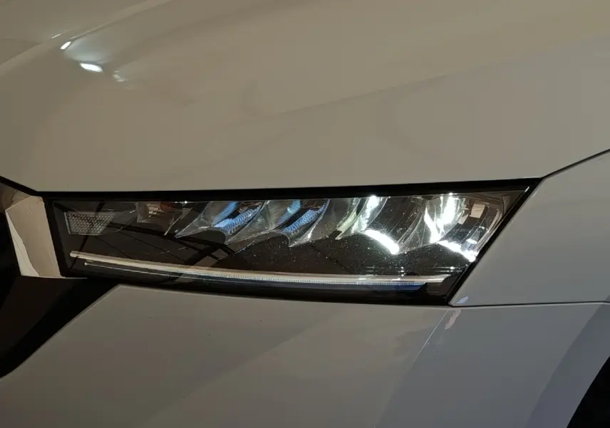 Gros plan sur le phare avant droit LED d'une Skoda Octavia blanche 2023, soulignant son design moderne et précis.