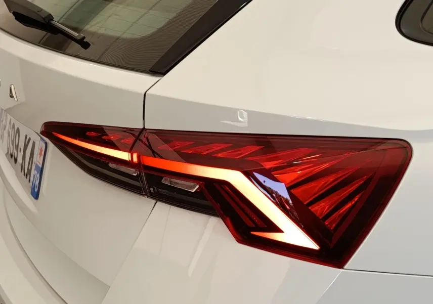 Gros plan sur le feu arrière droit allumé d’une Skoda Octavia blanche, version 2023, finition Ambition.