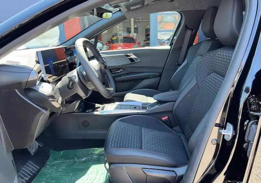 Vue intérieure côté conducteur de la Renault Clio 6 TCE 115 EDC Techno Plus noire étoilée, sièges avant en tissu et cuir.