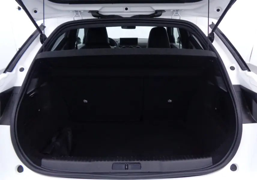 Coffre ouvert vu de l'arrière d'un DS3 Crossback blanc banquise, intérieur noir et banquette arrière visible.