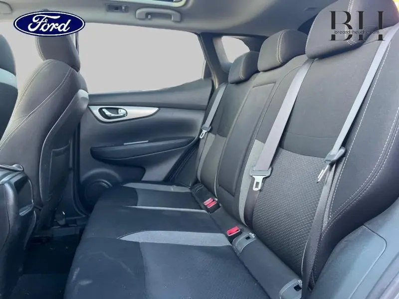 Vue latérale intérieure sur la banquette arrière noire d'un Nissan Qashqai 2019, avec ceintures de sécurité visibles.