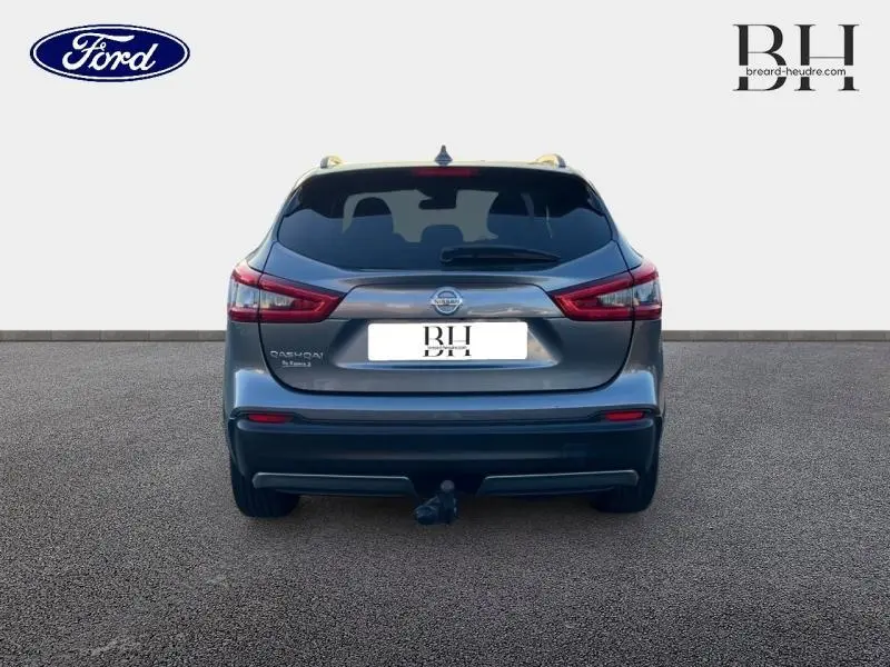 Vue arrière d'un Nissan Qashqai gris Squale 2019 avec attelage et feux arrière LED allumés.