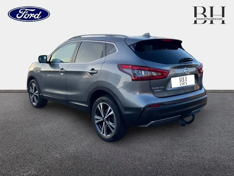 Vue 3/4 arrière droite du Nissan Qashqai 2019 gris Squale avec jantes alliage et attelage visible.