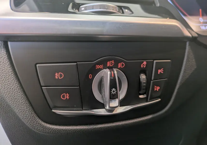 Gros plan sur les commandes d'éclairage du tableau de bord noir du BMW X4 blanc XDRIVE 2.0dA 190ch M SPORT 2021.