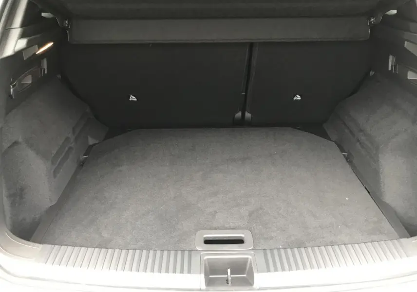 Coffre ouvert du Renault Austral blanc, vue intérieure montrant le plancher plat et les côtés garnis de tissu noir.