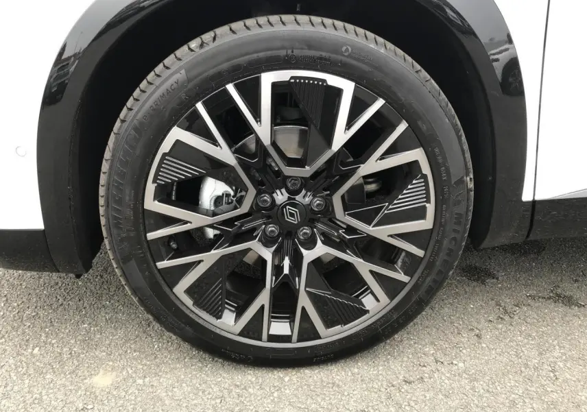 Gros plan sur la jante alliage 20 pouces noire et argentée du Renault Austral blanc, côté arrière droit.