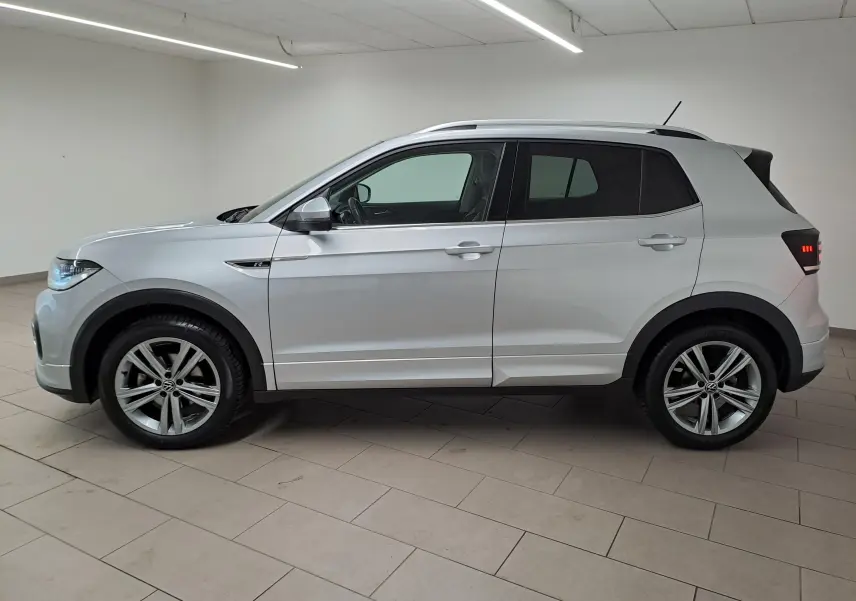 Vue de profil côté gauche d'un Volkswagen T-Cross 2022 argent Reflet d'Argent avec finition R-Line et jantes alliage.