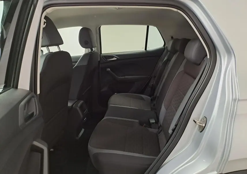Vue intérieure côté arrière droit du Volkswagen T-Cross 2022 argent, montrant les sièges arrière en tissu noir avec surpiqûres.