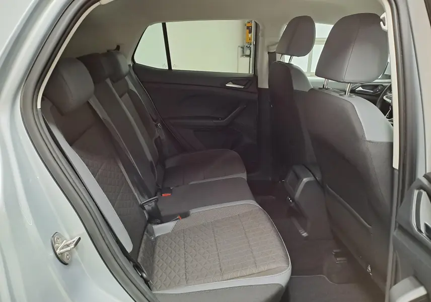 Vue intérieure côté gauche montrant la banquette arrière en tissu gris avec motifs, dans un Volkswagen T-Cross reflet d'argent 2022.