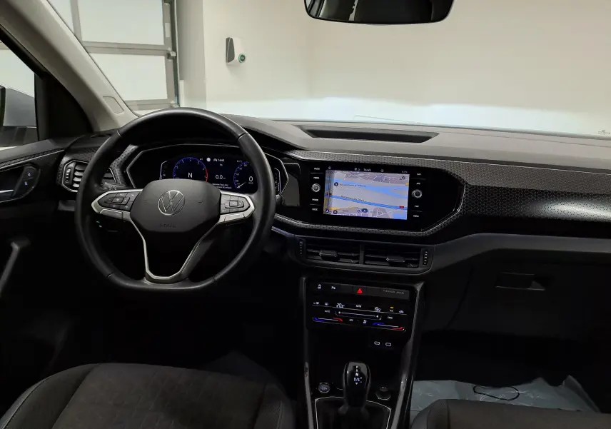 Vue intérieure avant du Volkswagen T-Cross 1.0 TSI 110 DSG7 R-Line 2022, tableau de bord avec écran tactile et volant multifonction noir.