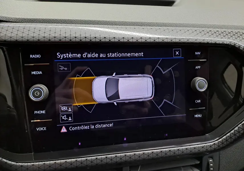 Écran central du Volkswagen T-Cross 2022 en reflet d'argent montrant le système d'aide au stationnement actif.